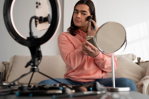 Foto gratuita maquillador masculino maquillándose a sí mismo