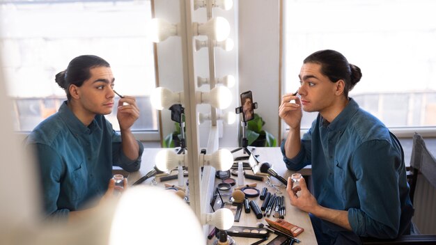 Maquillador masculino maquillándose a sí mismo