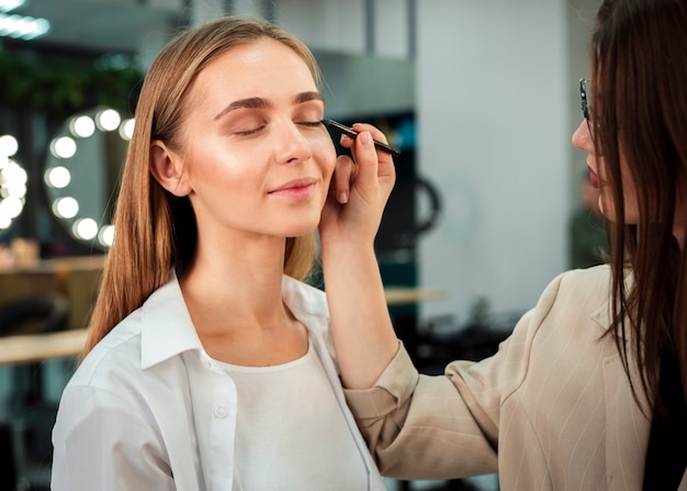 Maquilladora aplicando delineador de ojos