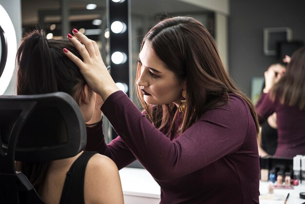 Foto gratuita maquilladora aplicando maquillaje