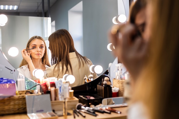 Maquilladora aplicando rímel en pestañas