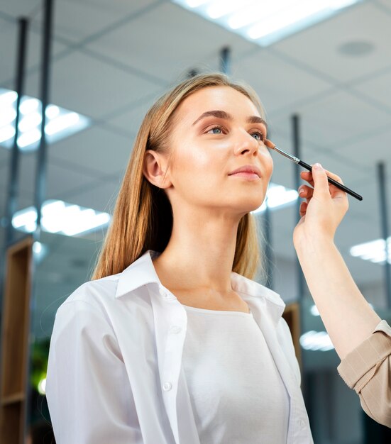 Maquilladora aplicando sombra de ojos con pincel