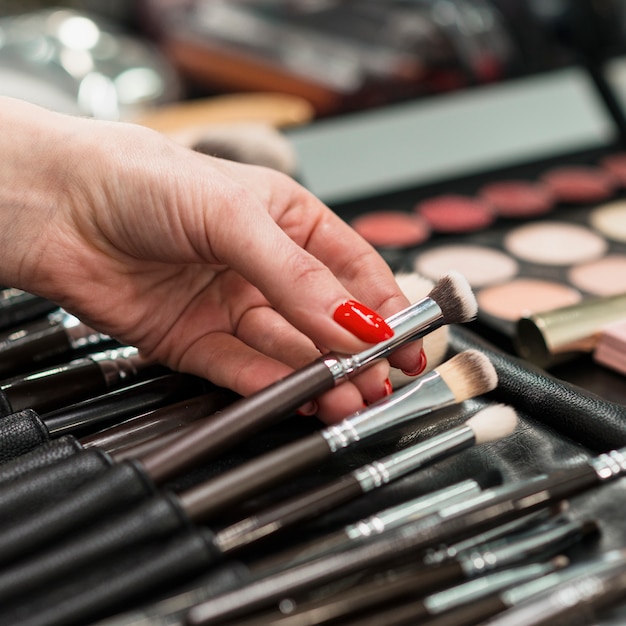 Maquilladora con colección de pinceles profesionales.