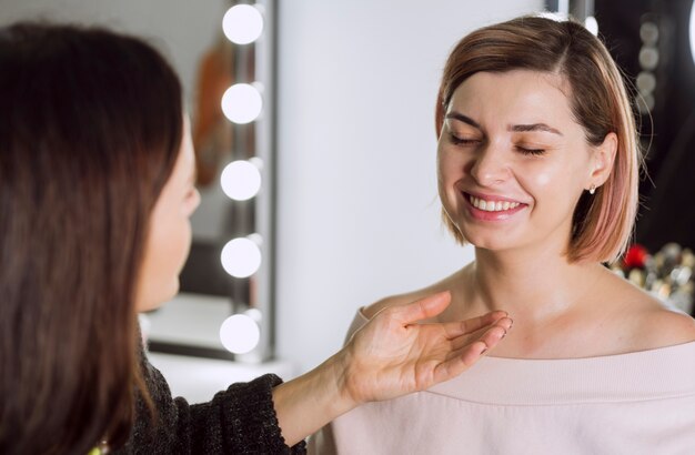 Maquilladora haciendo reír al cliente