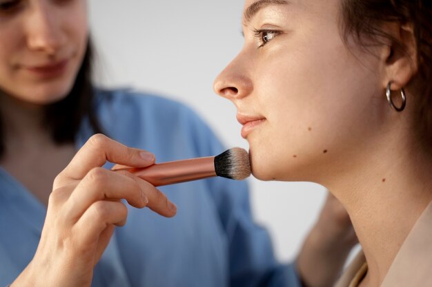 Maquilladora preparando modelo para sesión de fotos