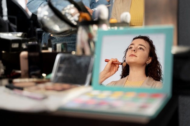 Maquilladora preparando modelo para sesión de fotos