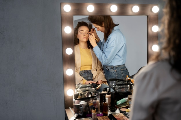 Maquilladora preparando modelo para sesión de fotos