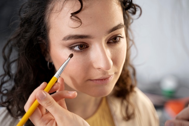 Foto gratuita maquilladora preparando modelo para sesión de fotos