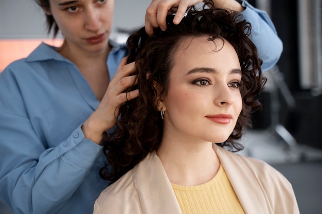 Foto gratuita maquilladora preparando modelo para sesión de fotos