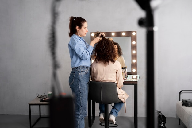 Foto gratuita maquilladora preparando modelo para sesión de fotos