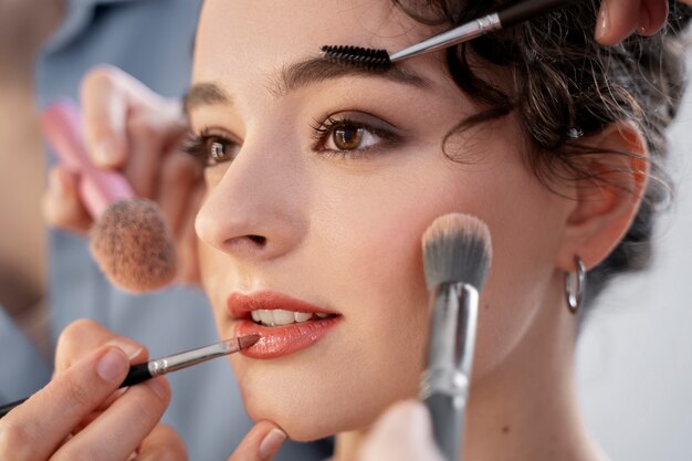 Maquilladora preparando modelo para sesión de fotos