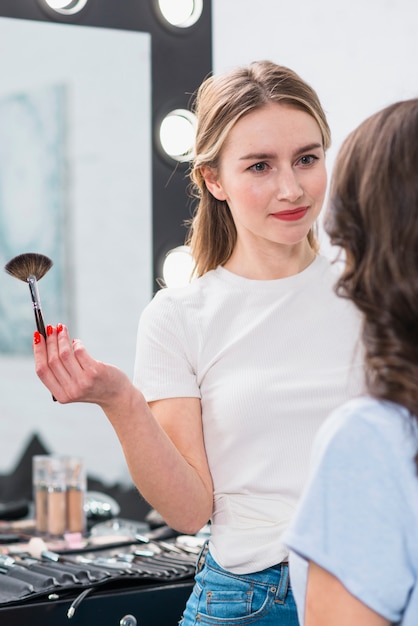 Maquilladora trabajando con modelo en estudio.