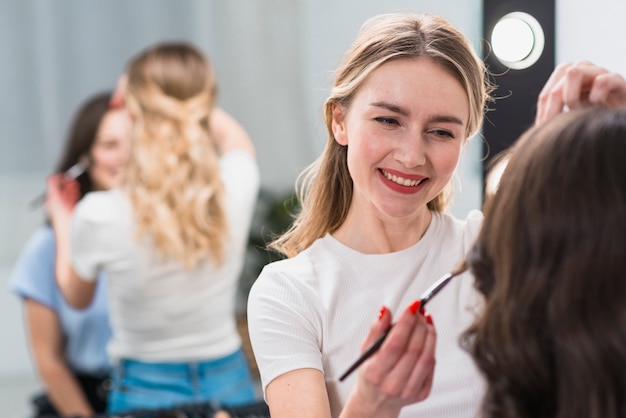 Foto gratuita maquilladora trabajando con modelo.