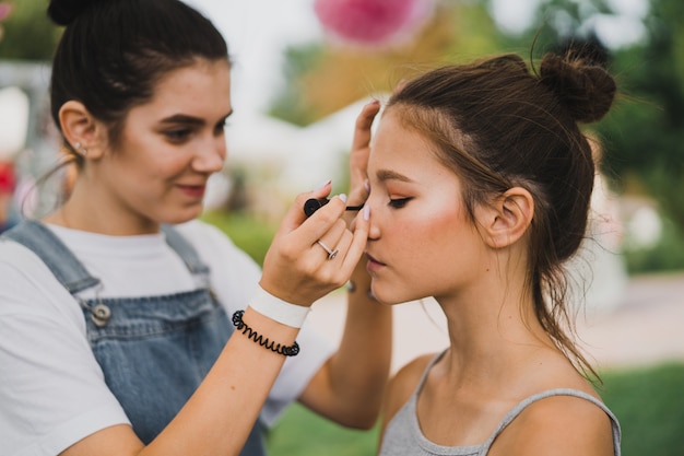 Maquillaje de clase magistral. chica hace maquillaje a su amiga