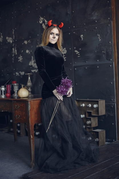Foto gratuita maquillaje de halloween hermosa mujer con peinado rubio. chica modelo en traje negro. tema de halloween.