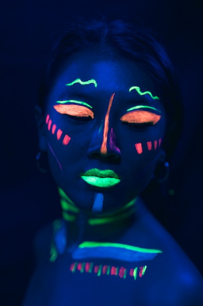 Maquillaje de pintura ultravioleta en el rostro de la mujer
