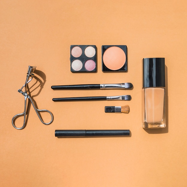 Maquillaje y productos de belleza cosméticos sobre fondo ocre
