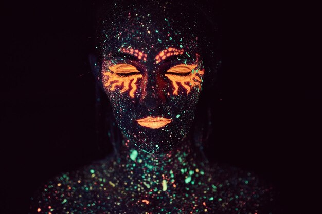 Maquillaje ultravioleta. Retrato de niña pintado con polvos fluorescentes. concepto de Halloween.