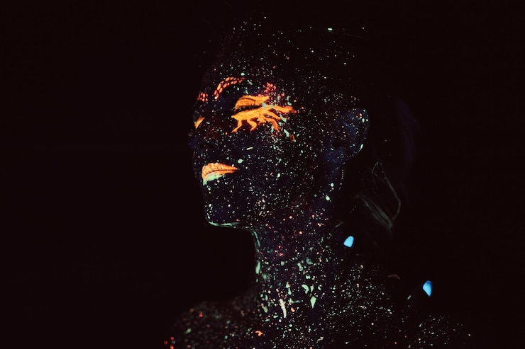 Foto gratuito maquillaje ultravioleta. retrato de niña pintado con polvos fluorescentes. concepto de halloween.