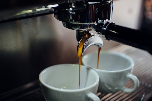 Máquina de café llenando dos tazas a la vez