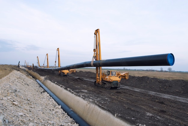 Máquinas de construcción de servicio pesado que transportan y colocan tuberías de gas en el suelo