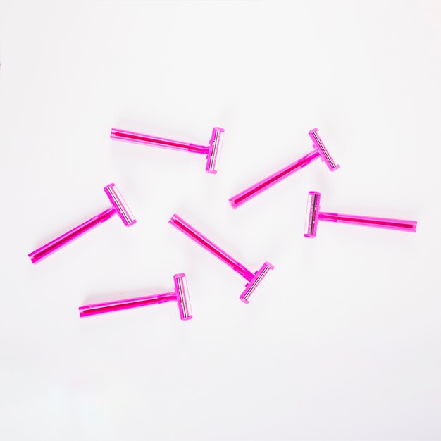 Maquinillas de afeitar femeninas rosadas en el fondo blanco