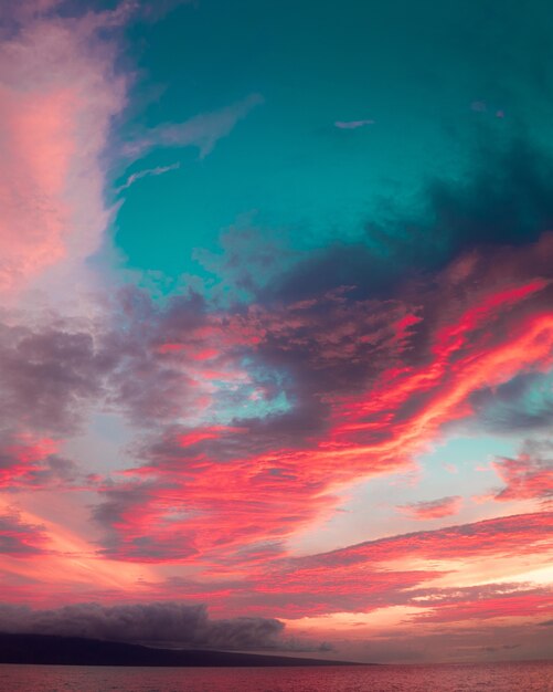 Mar bajo un cielo nublado durante una impresionante y colorida puesta de sol