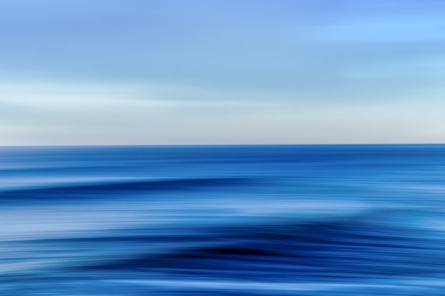 Mar durante una colorida puesta de sol con efecto de movimiento: una imagen genial para fondos de pantalla y fondos