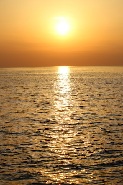 Mar bajo la luz del sol durante la puesta de sol dorada: perfecto para fondos de pantalla y fondos