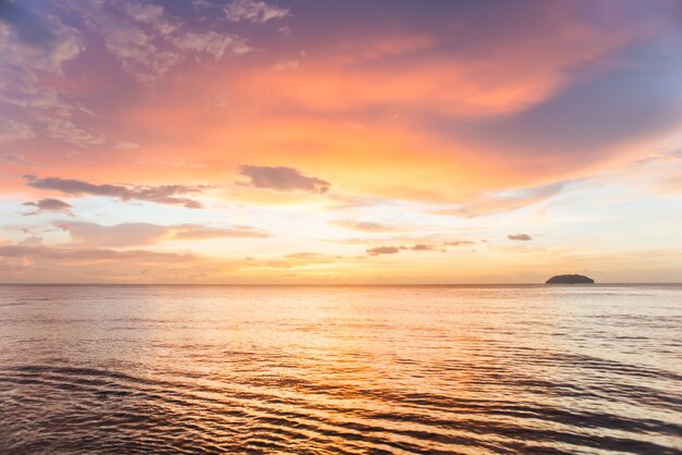 Mar con puesta de sol y nubes