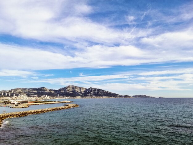 Mar rodeado de rocas bajo la luz del sol y un cielo nublado en Marsella en Francia