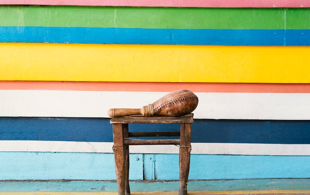 Foto gratuita maraca junto a una pared vibrante en rayas con espacio de copia