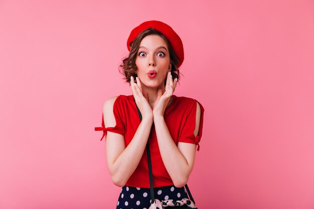 Maravillosa chica blanca en blusa roja posando con expresión de cara de besos. Mujer francesa romántica en pie bered.