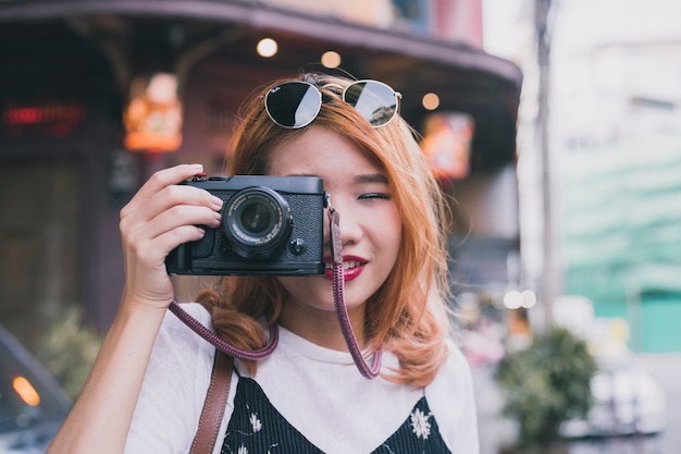 Foto gratuita maravillosa chica youn con cámara en la calle