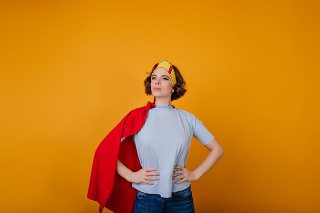 Maravillosa heroína en traje de moda posando en el espacio amarillo