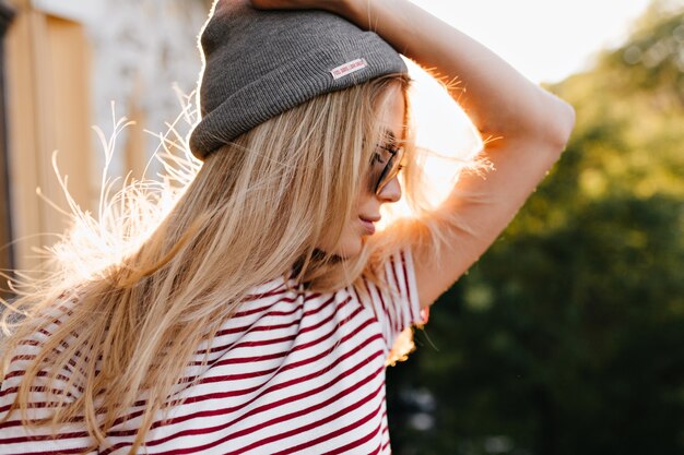 Maravillosa mujer posando al aire libre con sombrero gris