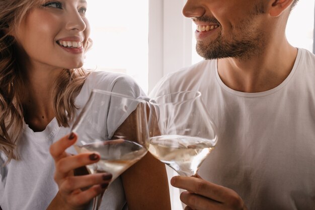 Maravillosa mujer rizada celebrando el aniversario con su novio. Pareja bebiendo champán.