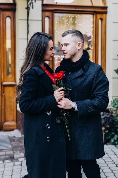 Maravillosa pareja romántica con rosas en la calle