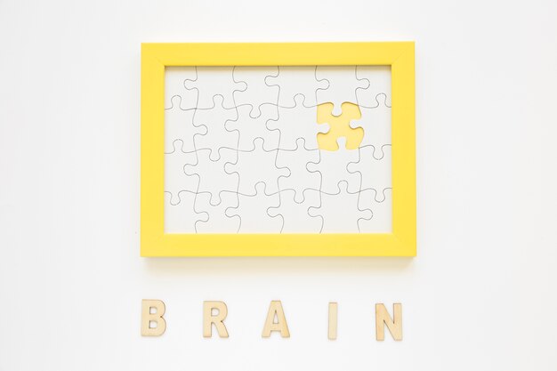 Marco amarillo con la pieza faltante del rompecabezas cerca de la palabra del cerebro