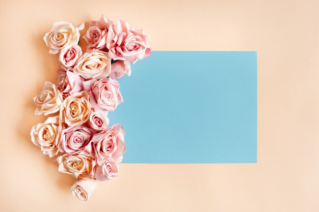 Marco azul con hermosas rosas alrededor. Foto gratis