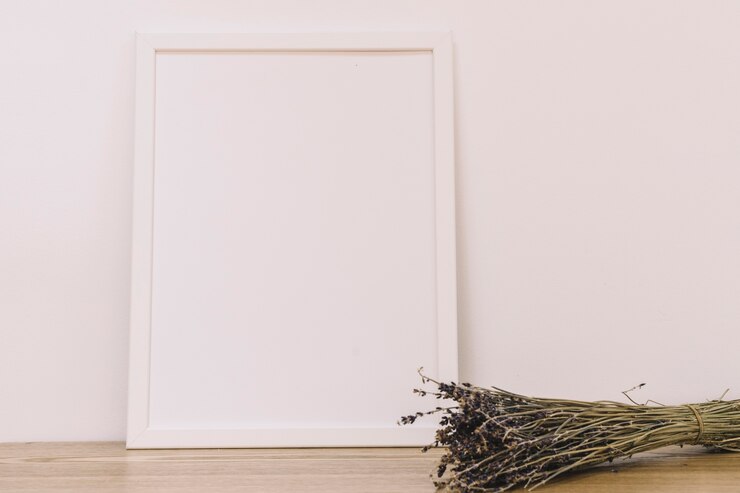 Foto gratuito marco en blanco apoyado a la pared con ramos