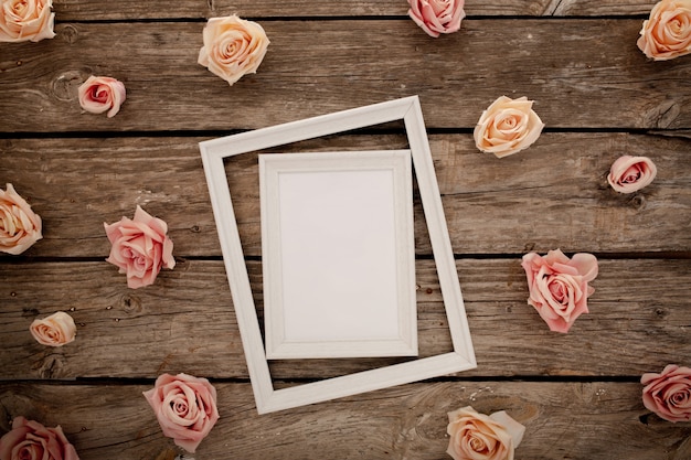 Foto gratuita marco de boda con rosas rosadas sobre fondo de madera marrón.