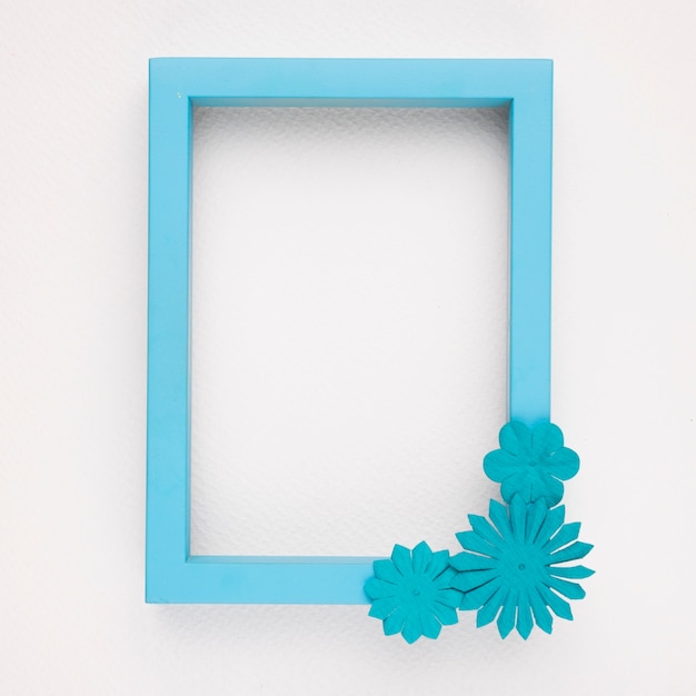 Un marco de borde azul vacío con flores sobre fondo blanco.