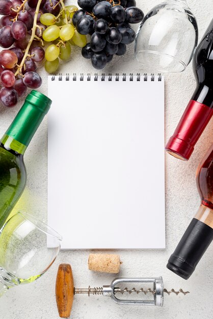 Marco de botellas de vino con cuaderno