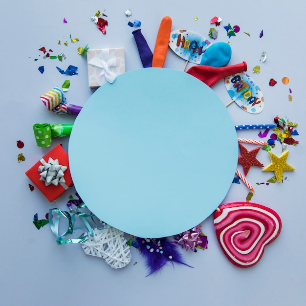 Marco circular azul en blanco sobre los artículos de la fiesta de cumpleaños en el fondo