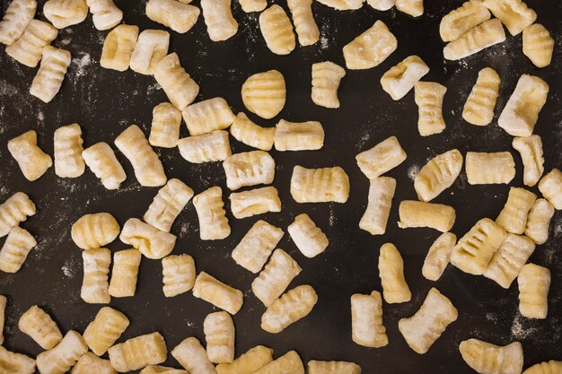 Marco completo de ñoquis de pasta casera sin cocer en encimera de cocina