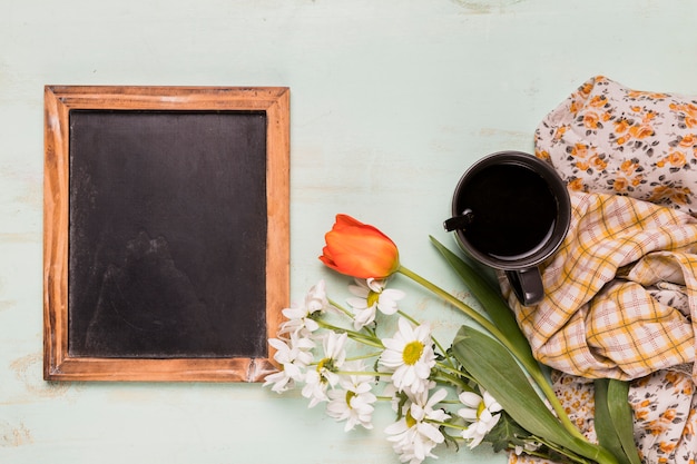 Foto gratuita marco decorado de pizarra con flores y taza.