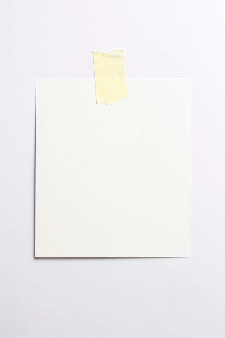 Marco fotográfico en blanco con sombras suaves y cinta adhesiva amarilla aislada sobre fondo de papel blanco