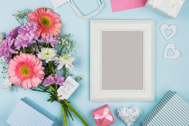 Marco de fotos cerca de flores frescas con título en etiqueta y decoraciones