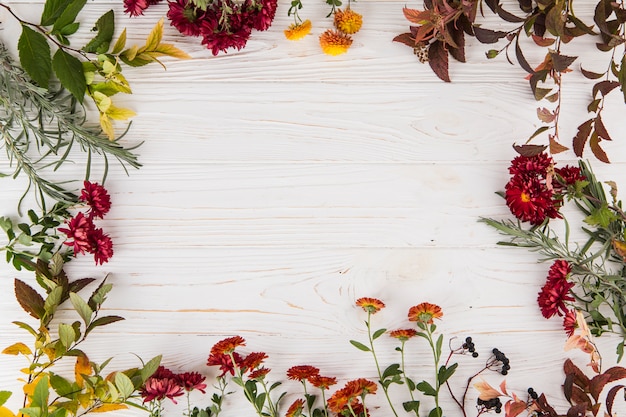 Marco hecho de diferentes flores en la mesa.